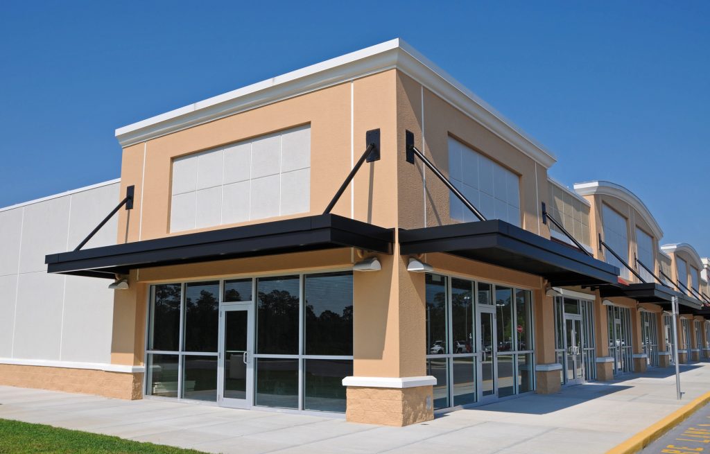 Modern commercial retail building with multiple storefronts, representing commercial lease opportunities and legal considerations for business tenants and property owners.